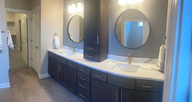 3390 Evening Star Dr, Green Bay, WI 54311 - full bath featuring double vanity, baseboards, a spacious closet, and wood finished floors