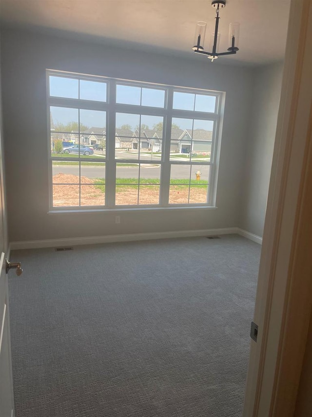 3390 Evening Star Dr, Green Bay, WI 54311 - carpeted spare room featuring a chandelier, baseboards, and plenty of natural light