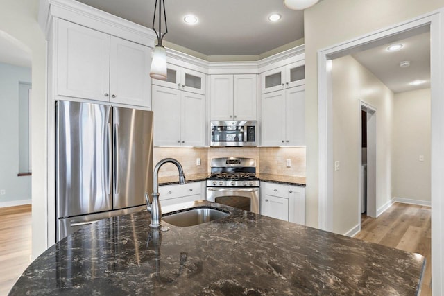 E12275 Timber Ridge Trl, Prairie Du Sac, WI 53578 - kitchen with appliances with stainless steel finishes, decorative light fixtures, a sink, tasteful backsplash, and light wood-type flooring
