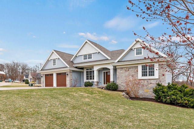 E12275 Timber Ridge Trl, Prairie Du Sac, WI 53578 - craftsman house featuring stone siding, a garage, concrete driveway, a shingled roof, and a front lawn