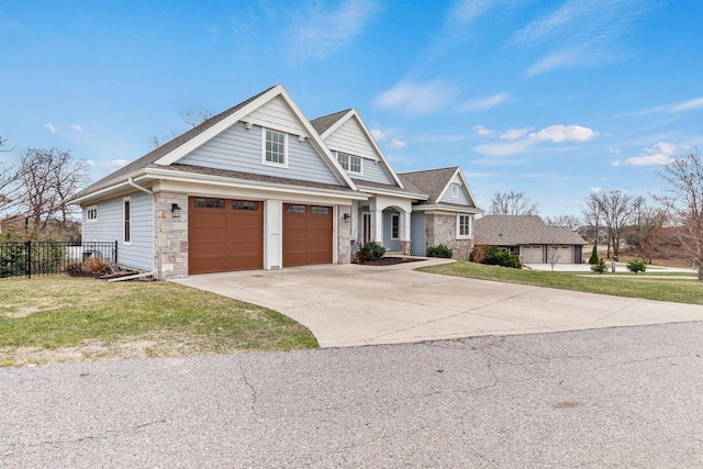 E12275 Timber Ridge Trl, Prairie Du Sac, WI 53578 - craftsman inspired home with stone siding, fence, concrete driveway, a front yard, and roof with shingles
