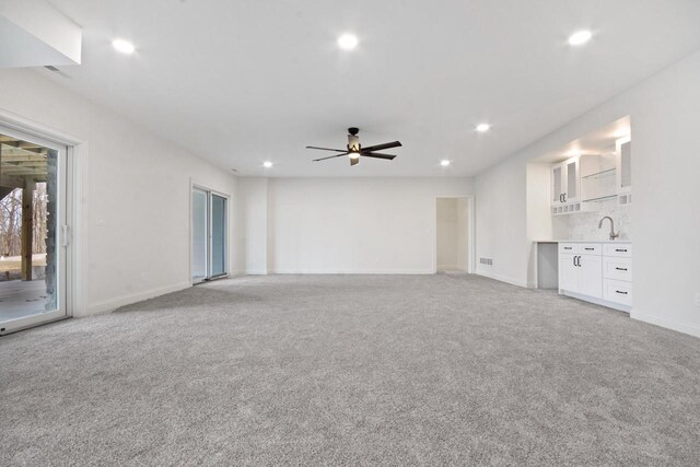 N2692 Forest Dr, Lake Geneva, WI 53147 - unfurnished living room featuring light carpet, a ceiling fan, baseboards, recessed lighting, and a sink