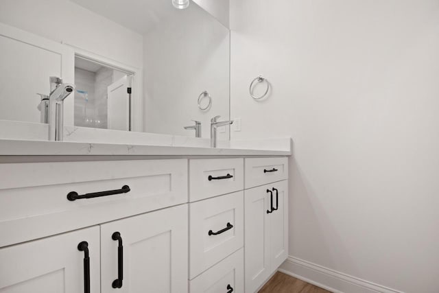N2692 Forest Dr, Lake Geneva, WI 53147 - bathroom with double vanity, baseboards, and wood finished floors