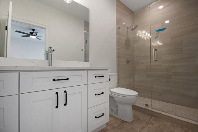 N2692 Forest Dr, Lake Geneva, WI 53147 - bathroom with toilet, vanity, a stall shower, wood finished floors, and a ceiling fan