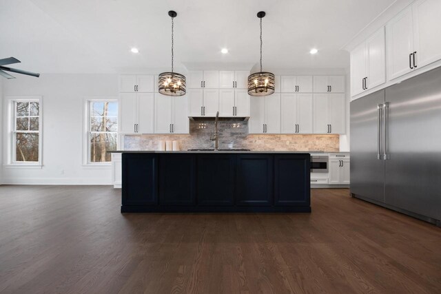 N2692 Forest Dr, Lake Geneva, WI 53147 - kitchen with stainless steel built in fridge, a chandelier, dark wood-style flooring, decorative backsplash, and white cabinetry