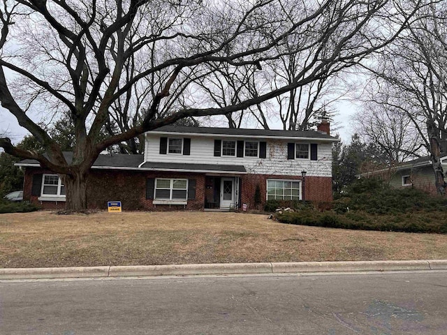 5711 Pheasant Hill Rd, Monona, WI 53716 - traditional-style house with a chimney, a front lawn, and brick siding