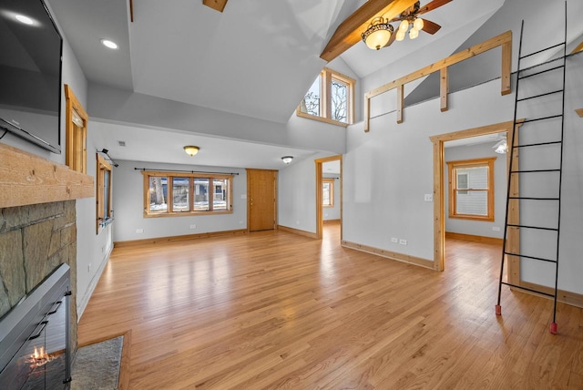 556 Highland Rd, Williams Bay, WI 53191 - unfurnished living room with high vaulted ceiling, a glass covered fireplace, light wood-style floors, baseboards, and recessed lighting