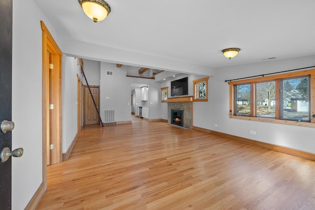 556 Highland Rd, Williams Bay, WI 53191 - unfurnished living room featuring light wood-type flooring, a lit fireplace, and baseboards