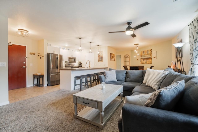 living room with a ceiling fan, light tile patterned floors, and light colored carpet