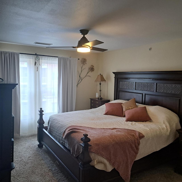 carpeted bedroom featuring visible vents, a textured ceiling, and ceiling fan