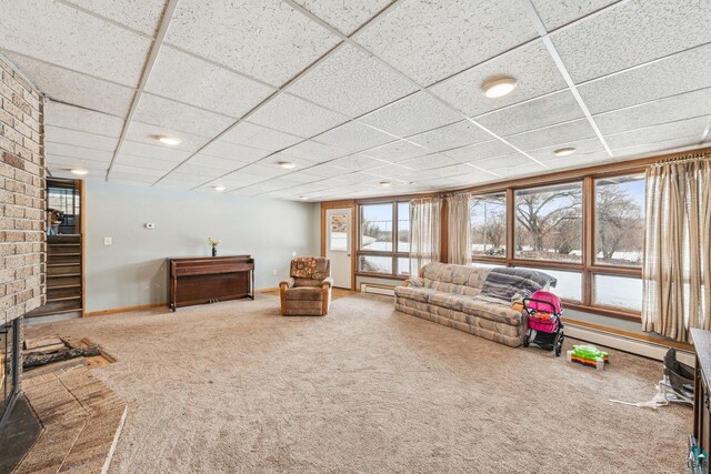 2507 Junction Rd, Ashland, WI 54806 - unfurnished living room featuring a baseboard radiator, baseboards, carpet flooring, and a drop ceiling