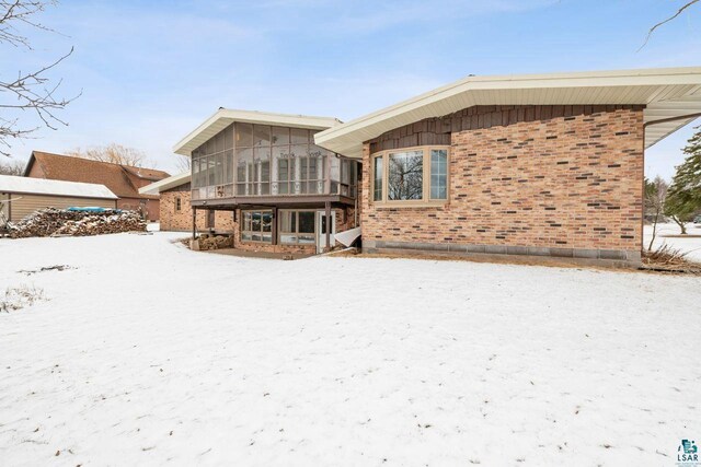 2507 Junction Rd, Ashland, WI 54806 - snow covered house featuring a sunroom and brick siding