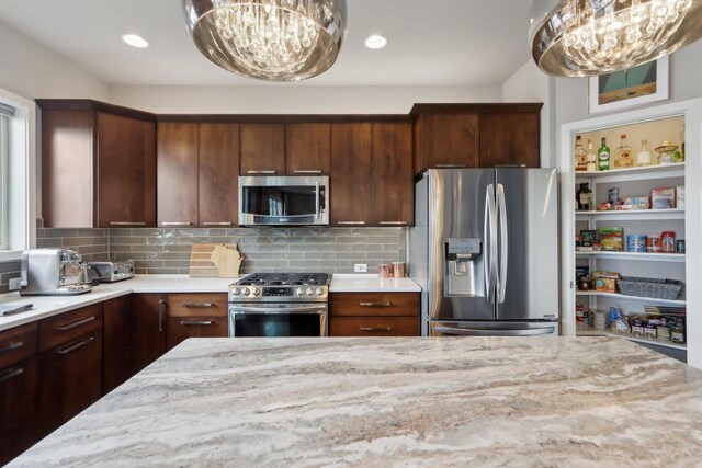 328 Venus Way, Madison, WI 53718 - kitchen featuring light stone countertops, a chandelier, tasteful backsplash, and appliances with stainless steel finishes