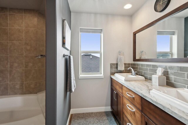 328 Venus Way, Madison, WI 53718 - bathroom featuring decorative backsplash, a shower, baseboards, double vanity, and a sink