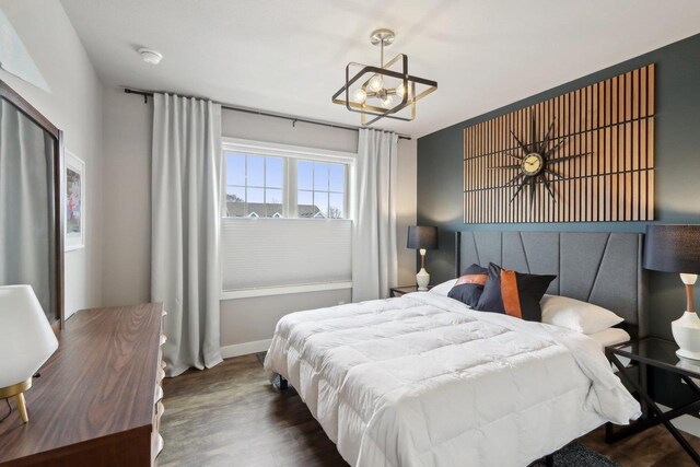 328 Venus Way, Madison, WI 53718 - bedroom with baseboards, wood finished floors, and an inviting chandelier