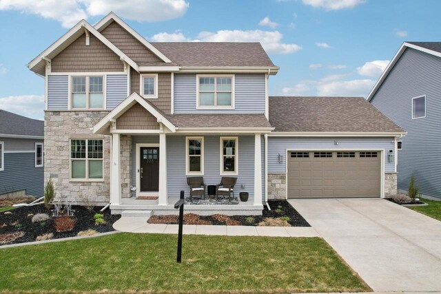 328 Venus Way, Madison, WI 53718 - craftsman-style house with an attached garage, stone siding, driveway, covered porch, and a shingled roof
