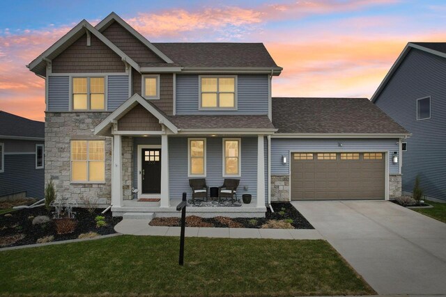 328 Venus Way, Madison, WI 53718 - craftsman house featuring stone siding, an attached garage, concrete driveway, roof with shingles, and a porch