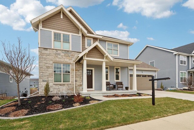 328 Venus Way, Madison, WI 53718 - craftsman inspired home with cooling unit, concrete driveway, stone siding, covered porch, and a garage