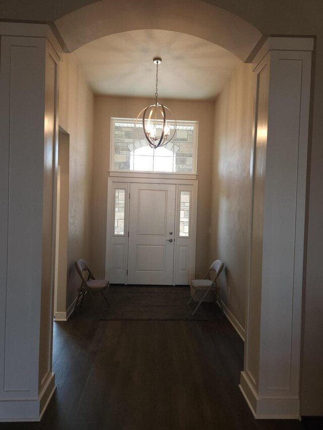 5684 N Kestrel Cir, Appleton, WI 54913 - entrance foyer featuring arched walkways, baseboards, a notable chandelier, and dark wood finished floors