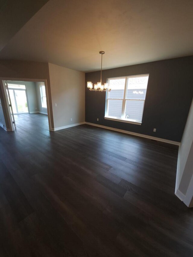 5684 N Kestrel Cir, Appleton, WI 54913 - unfurnished room featuring an inviting chandelier, dark wood-style floors, and baseboards