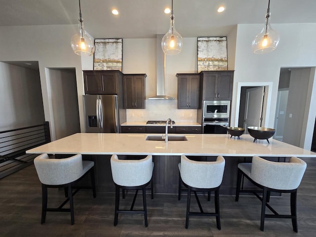 5684 N Kestrel Cir, Appleton, WI 54913 - kitchen featuring a large island with sink, stainless steel appliances, backsplash, a sink, and dark brown cabinets