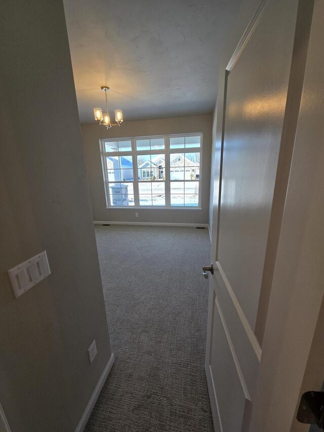 2544 E Baldeagle Dr, Appleton, WI 54913 - hallway featuring baseboards, a notable chandelier, and dark colored carpet