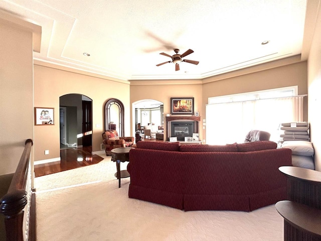25621 Honeycut Ave, Tomah, WI 54660 - living room featuring baseboards, arched walkways, a glass covered fireplace, and a ceiling fan