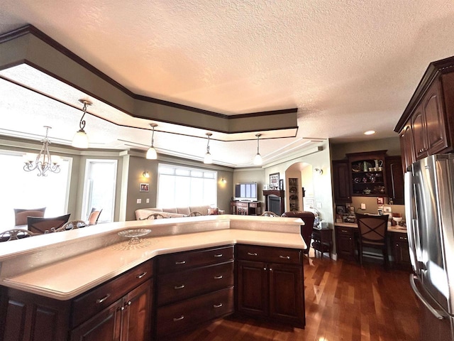 25621 Honeycut Ave, Tomah, WI 54660 - kitchen featuring light countertops, freestanding refrigerator, open floor plan, arched walkways, and dark wood-type flooring
