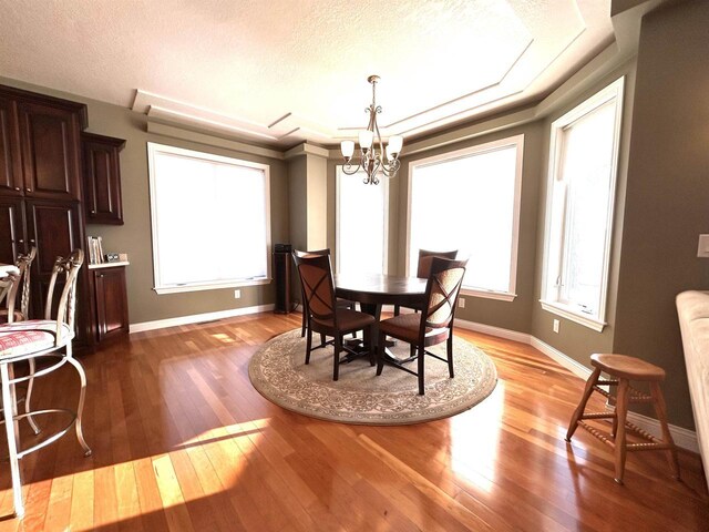25621 Honeycut Ave, Tomah, WI 54660 - dining room with hardwood / wood-style floors, a notable chandelier, baseboards, and a textured ceiling