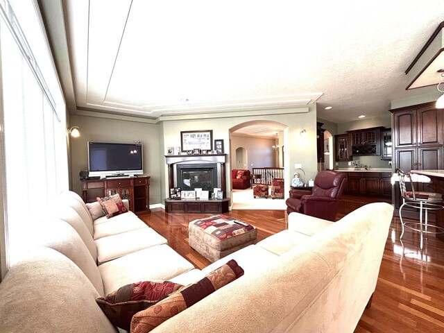 25621 Honeycut Ave, Tomah, WI 54660 - living area featuring arched walkways, dark wood-style flooring, a textured ceiling, and recessed lighting