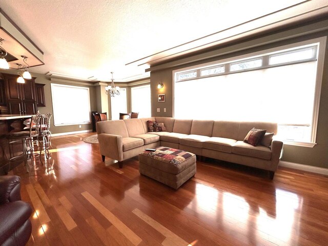 25621 Honeycut Ave, Tomah, WI 54660 - living area with baseboards, a textured ceiling, wood finished floors, and an inviting chandelier