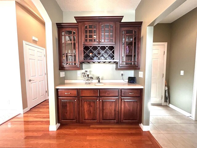 25621 Honeycut Ave, Tomah, WI 54660 - bar featuring indoor bar, baseboards, a textured ceiling, and light wood-style flooring