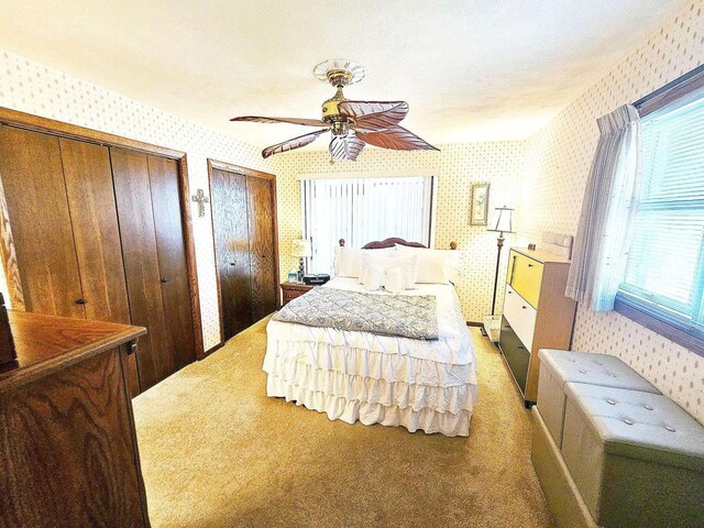 1090 Shabbona Dr, Fontana, WI 53125 - carpeted bedroom featuring wallpapered walls, two closets, and a ceiling fan