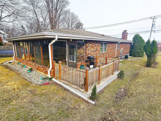 1090 Shabbona Dr, Fontana, WI 53125 - back of house with a chimney, central air condition unit, a deck, brick siding, and a sunroom