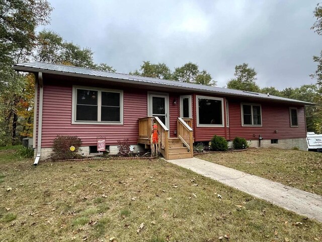single story home featuring metal roof and a front yard