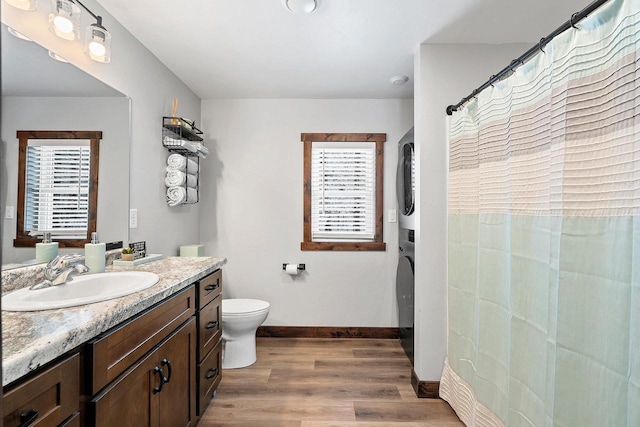 W11490 Boat Landing 7 Rd, Athelstane, WI 54104 - full bathroom featuring stacked washer and clothes dryer, baseboards, wood finished floors, toilet, and vanity