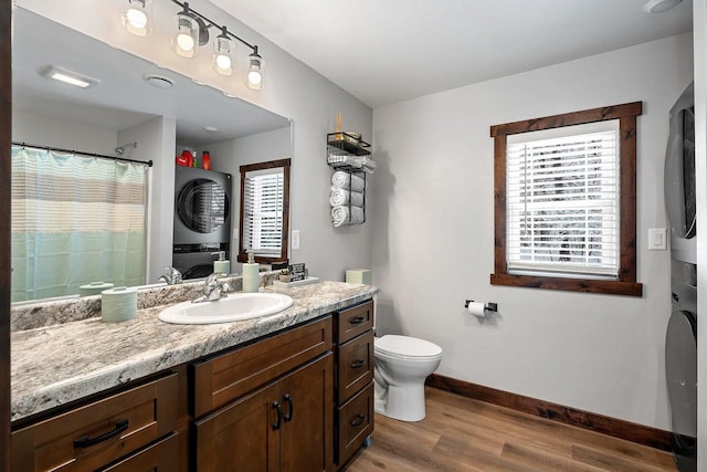 W11490 Boat Landing 7 Rd, Athelstane, WI 54104 - bathroom with stacked washer and clothes dryer, vanity, toilet, baseboards, and wood finished floors