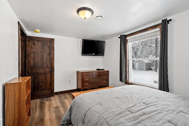 W11490 Boat Landing 7 Rd, Athelstane, WI 54104 - bedroom featuring baseboards, cooling unit, and wood finished floors