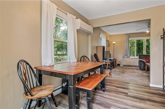 806 Oak Ridge Dr, Osceola, WI 54020 - dining area featuring a wall mounted air conditioner, healthy amount of natural light, wood finished floors, and baseboards