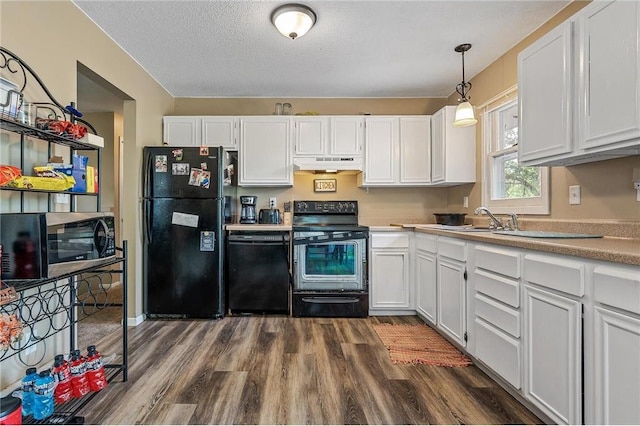 806 Oak Ridge Dr, Osceola, WI 54020 - kitchen with black appliances, under cabinet range hood, white cabinetry, dark wood-style flooring, and a textured ceiling