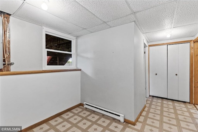 806 Oak Ridge Dr, Osceola, WI 54020 - below grade area featuring a baseboard radiator, light floors, baseboards, and a drop ceiling