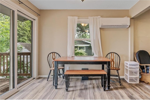 806 Oak Ridge Dr, Osceola, WI 54020 - dining room with a wall unit AC, wood finished floors, healthy amount of natural light, and baseboards