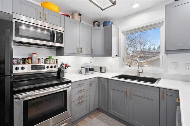 3374 Gerrard Ave, Eau Claire, WI 54701 - kitchen featuring light countertops, gray cabinets, a sink, and stainless steel appliances