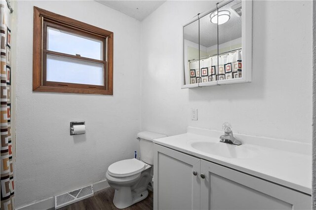 3374 Gerrard Ave, Eau Claire, WI 54701 - full bath featuring a shower with curtain, vanity, toilet, visible vents, and wood finished floors