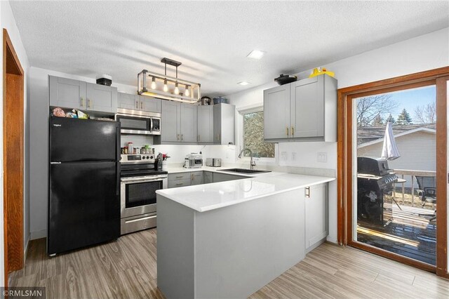 3374 Gerrard Ave, Eau Claire, WI 54701 - kitchen with gray cabinetry, a sink, stainless steel appliances, and a peninsula