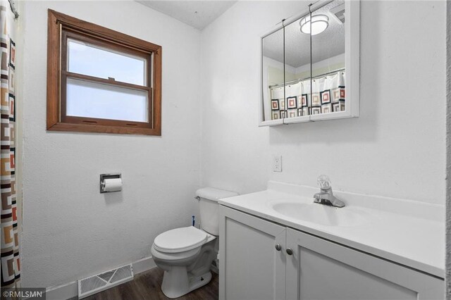3374 Gerrard Ave, Eau Claire, WI 54701 - full bathroom featuring a shower with shower curtain, toilet, vanity, wood finished floors, and visible vents