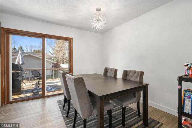 3374 Gerrard Ave, Eau Claire, WI 54701 - dining room featuring an inviting chandelier, a textured ceiling, baseboards, and light wood-type flooring