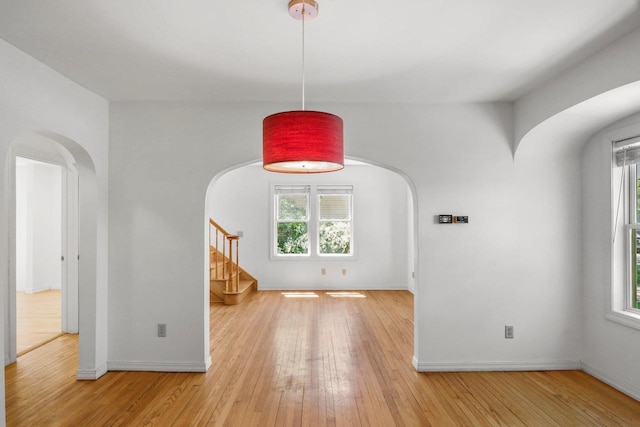 725 Eugenia Ave, Madison, WI 53705 - spare room with arched walkways, light wood-style flooring, and baseboards