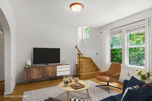 725 Eugenia Ave, Madison, WI 53705 - living room with arched walkways, wood finished floors, stairs, and baseboards