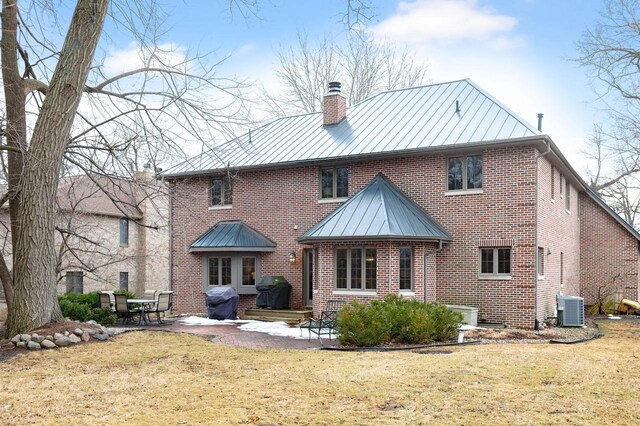 36082 N Beach Rd, Oconomowoc, WI 53066 - back of property with central AC unit, metal roof, a standing seam roof, and brick siding